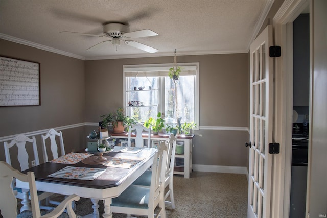 dining space with ceiling fan, ornamental molding, carpet, and a textured ceiling