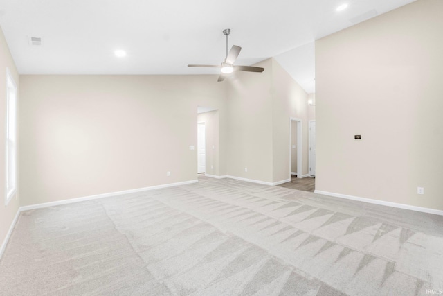 carpeted empty room featuring vaulted ceiling and ceiling fan