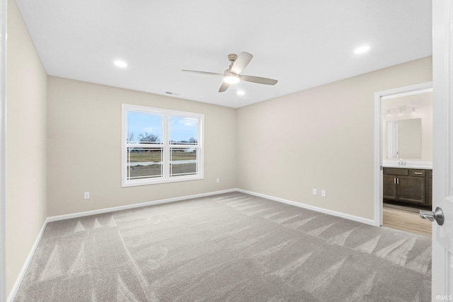 interior space featuring ceiling fan, light colored carpet, and connected bathroom