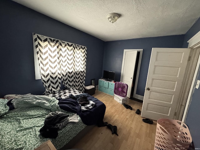 bedroom with hardwood / wood-style floors and a textured ceiling