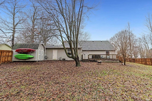 rear view of house featuring a wooden deck and a storage shed