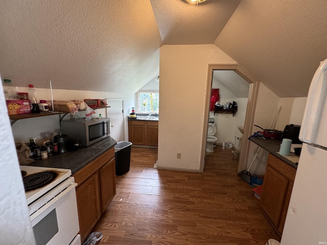 kitchen featuring white electric stove, dark hardwood / wood-style flooring, vaulted ceiling, and a textured ceiling