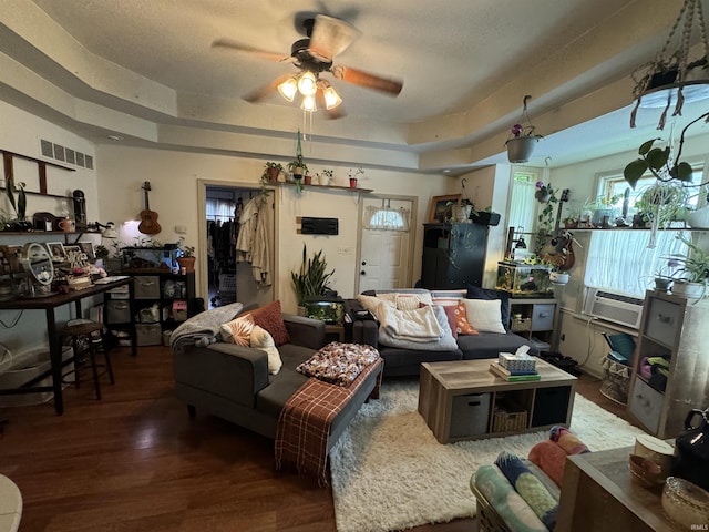 living room featuring a tray ceiling, dark hardwood / wood-style floors, and ceiling fan