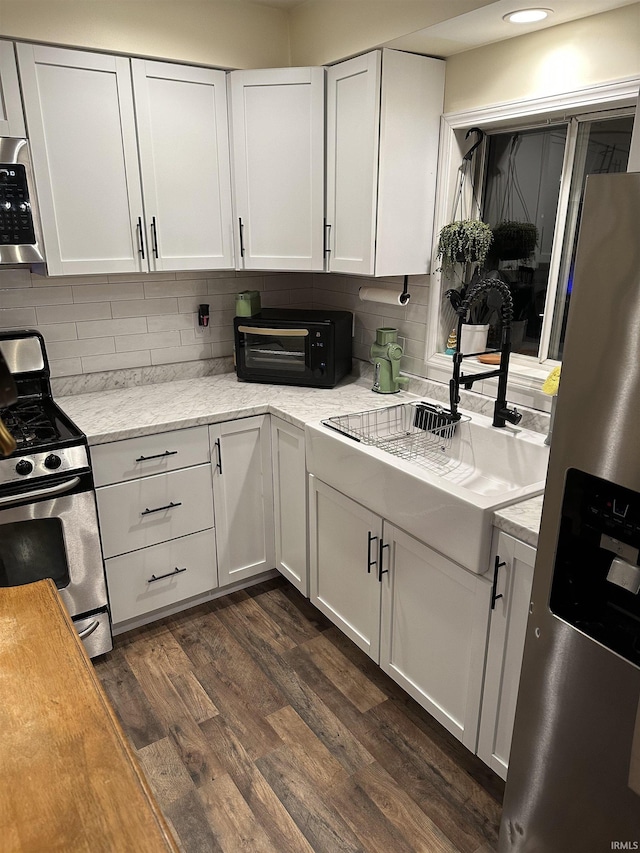 kitchen with sink, white cabinetry, tasteful backsplash, dark hardwood / wood-style floors, and stainless steel appliances