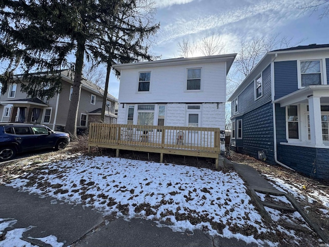 snow covered house featuring a wooden deck