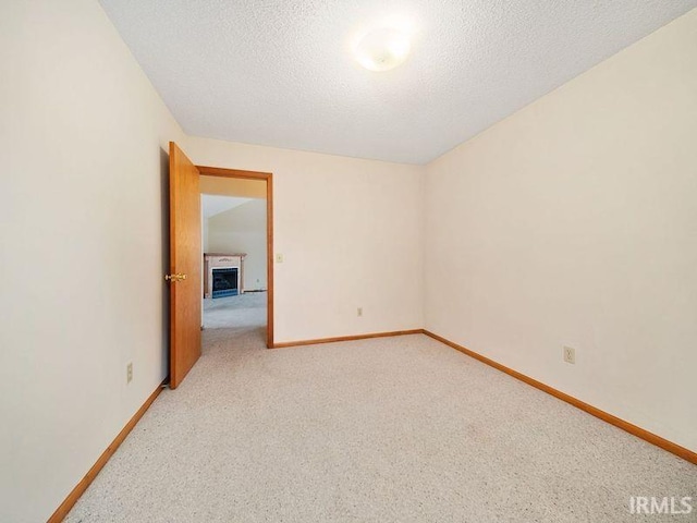 carpeted empty room with a textured ceiling