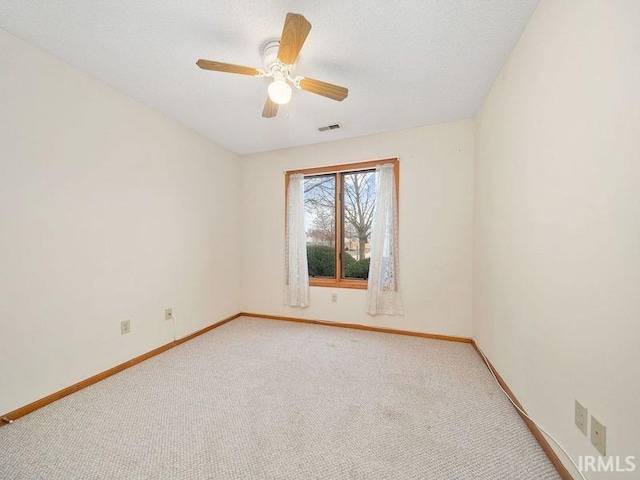 spare room featuring ceiling fan, carpet, and a textured ceiling