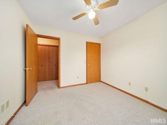 unfurnished bedroom with light carpet and ceiling fan