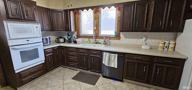 kitchen with white appliances, light tile patterned floors, sink, and backsplash