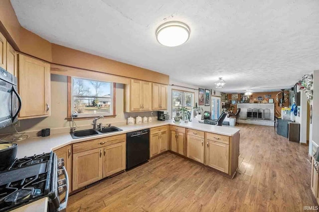 kitchen featuring plenty of natural light, sink, kitchen peninsula, and black appliances