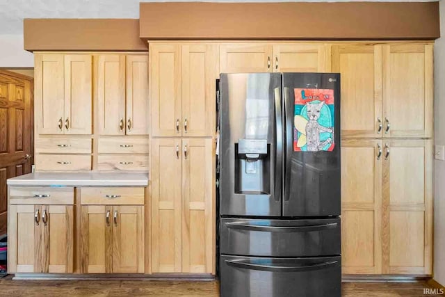 kitchen with light brown cabinetry, stainless steel fridge with ice dispenser, and hardwood / wood-style floors