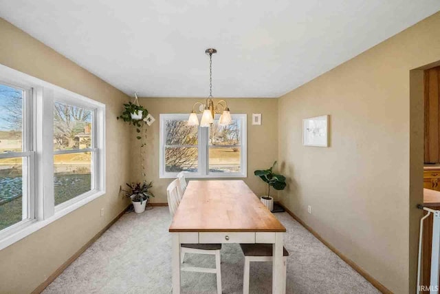 dining area with light colored carpet and an inviting chandelier