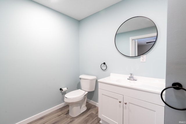 bathroom featuring wood-type flooring, toilet, and vanity