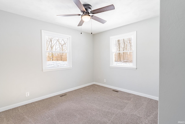 empty room with ceiling fan, a healthy amount of sunlight, and carpet floors