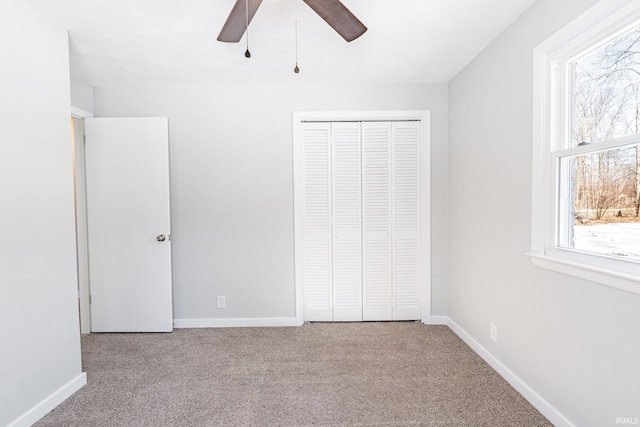 unfurnished bedroom featuring light carpet, a closet, and ceiling fan