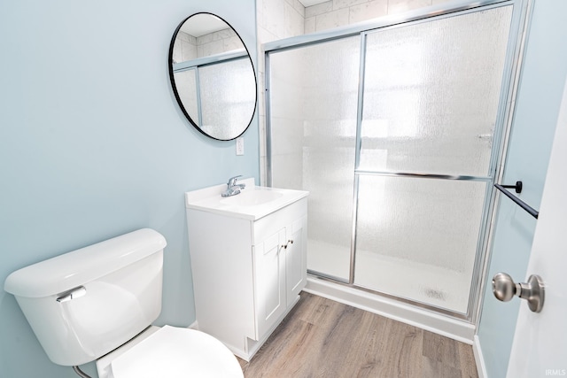 bathroom featuring hardwood / wood-style flooring, vanity, toilet, and walk in shower