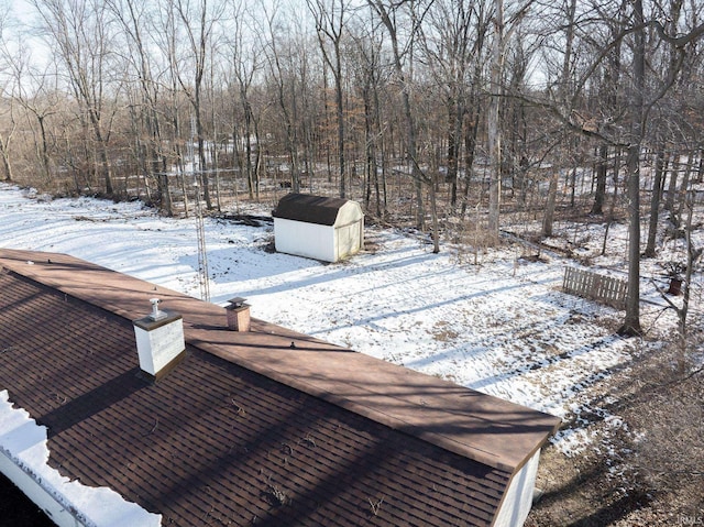 yard layered in snow with a storage unit