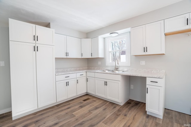 kitchen featuring white cabinetry, sink, and hardwood / wood-style floors