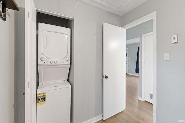 washroom featuring light wood-type flooring and stacked washer / dryer