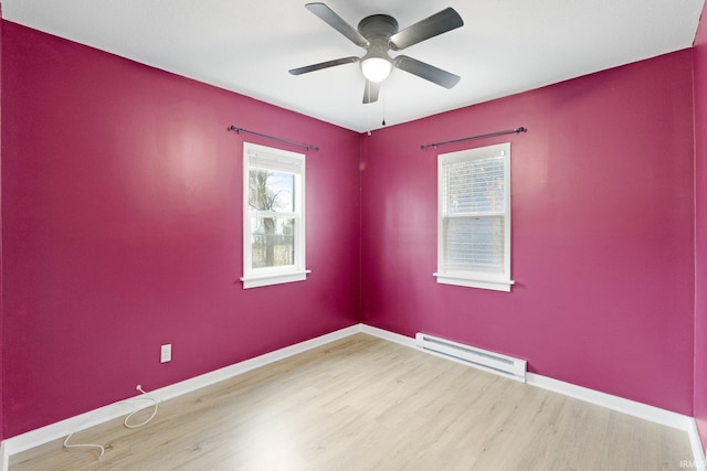 empty room with a baseboard radiator, ceiling fan, and light hardwood / wood-style floors