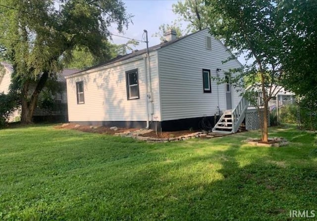 rear view of house featuring a yard