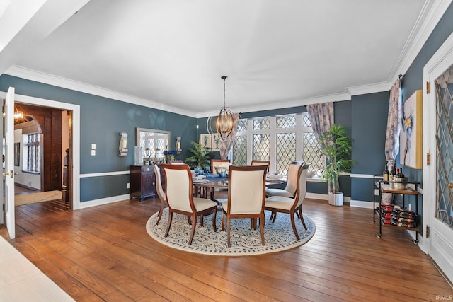 dining room with ornamental molding, dark hardwood / wood-style floors, and a notable chandelier