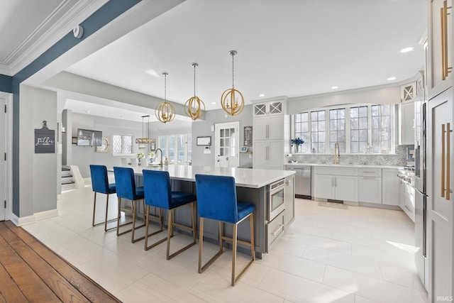 kitchen featuring appliances with stainless steel finishes, a center island, pendant lighting, and white cabinets