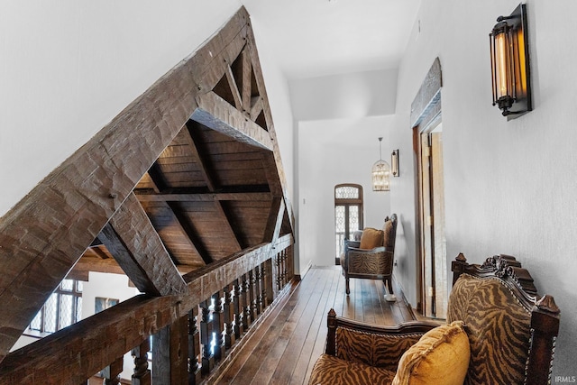 hallway with wood-type flooring and a high ceiling