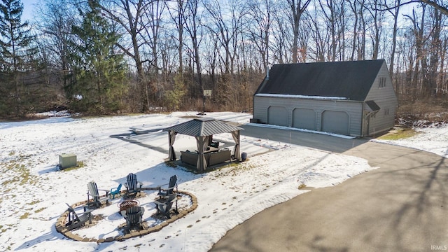 exterior space with a garage, an outdoor structure, and a fire pit