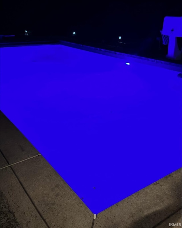 view of pool at twilight