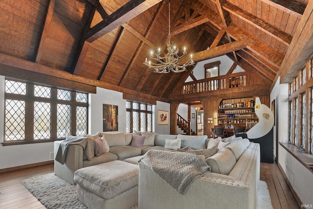 living room with an inviting chandelier, wood-type flooring, high vaulted ceiling, wooden ceiling, and beamed ceiling