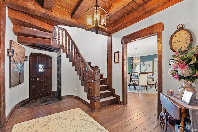 foyer with wooden ceiling, beam ceiling, hardwood / wood-style floors, and a notable chandelier