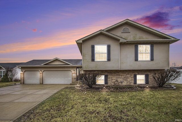 tri-level home with a garage and a lawn