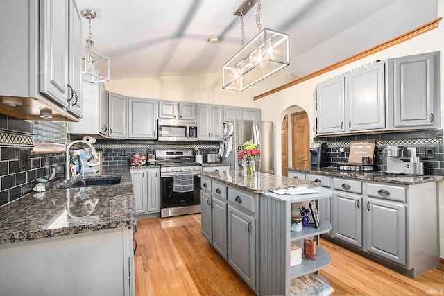 kitchen with sink, gray cabinetry, appliances with stainless steel finishes, a kitchen island, and pendant lighting