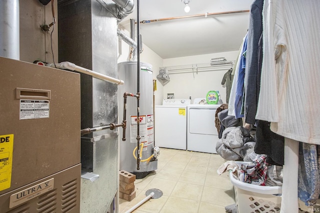 washroom with washer and dryer, water heater, and light tile patterned flooring