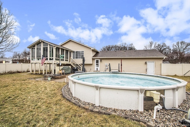 view of pool with a sunroom and a yard