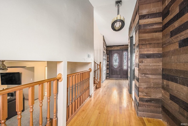 hall with wooden walls and light hardwood / wood-style floors