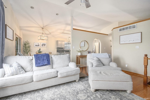 living room with wood-type flooring, lofted ceiling, and ceiling fan