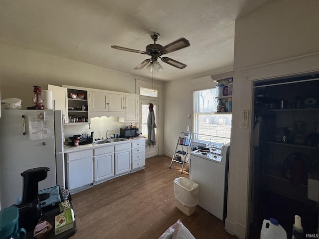 kitchen with white cabinetry, refrigerator, sink, and hardwood / wood-style floors