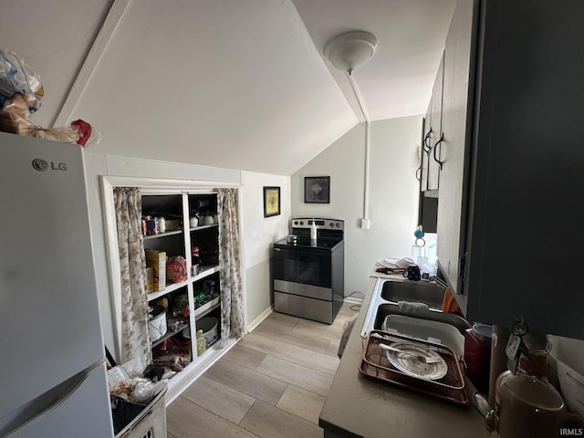 kitchen with lofted ceiling, white fridge, and stainless steel electric range oven