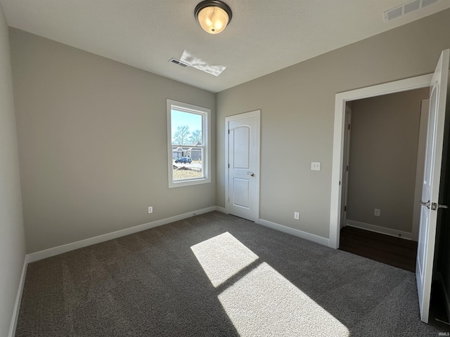 unfurnished bedroom featuring white refrigerator and dark colored carpet