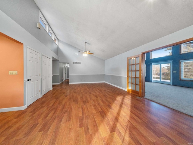 spare room with a textured ceiling, high vaulted ceiling, ceiling fan, and light wood-type flooring