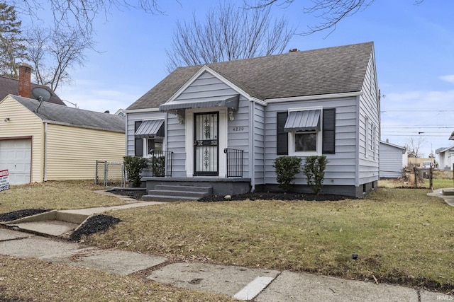 bungalow-style home featuring a garage and a front yard