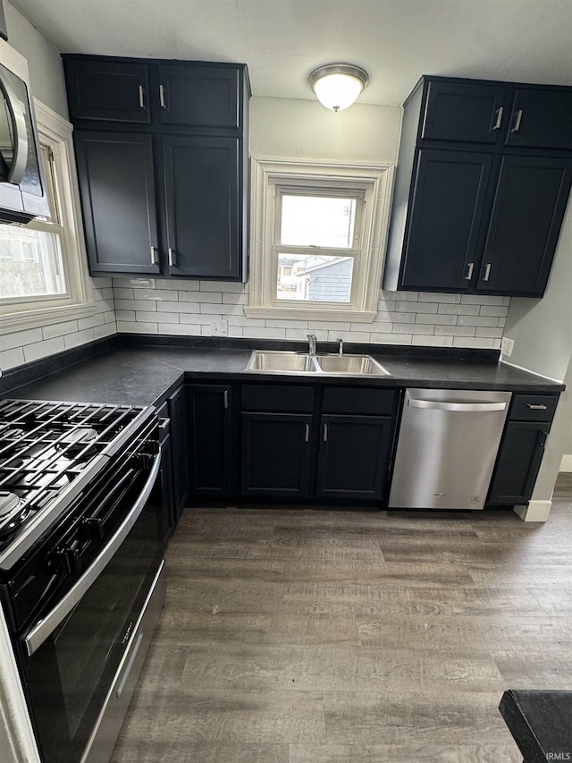 kitchen with dark hardwood / wood-style flooring, sink, backsplash, and stainless steel appliances