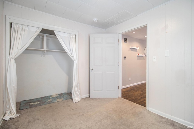 unfurnished bedroom with ornamental molding, a closet, and carpet