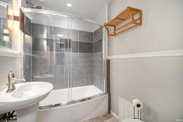 bathroom with sink and shower / bath combination with glass door