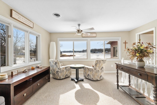 sitting room with ceiling fan and carpet