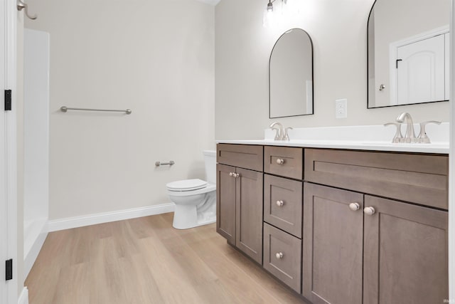 bathroom featuring wood-type flooring, vanity, and toilet