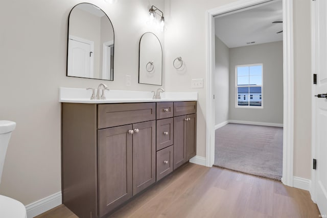 bathroom featuring vanity, hardwood / wood-style flooring, and toilet