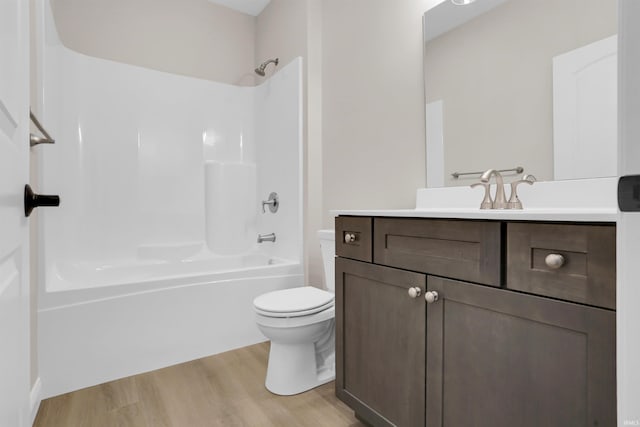 full bathroom with hardwood / wood-style flooring,  shower combination, vanity, and toilet